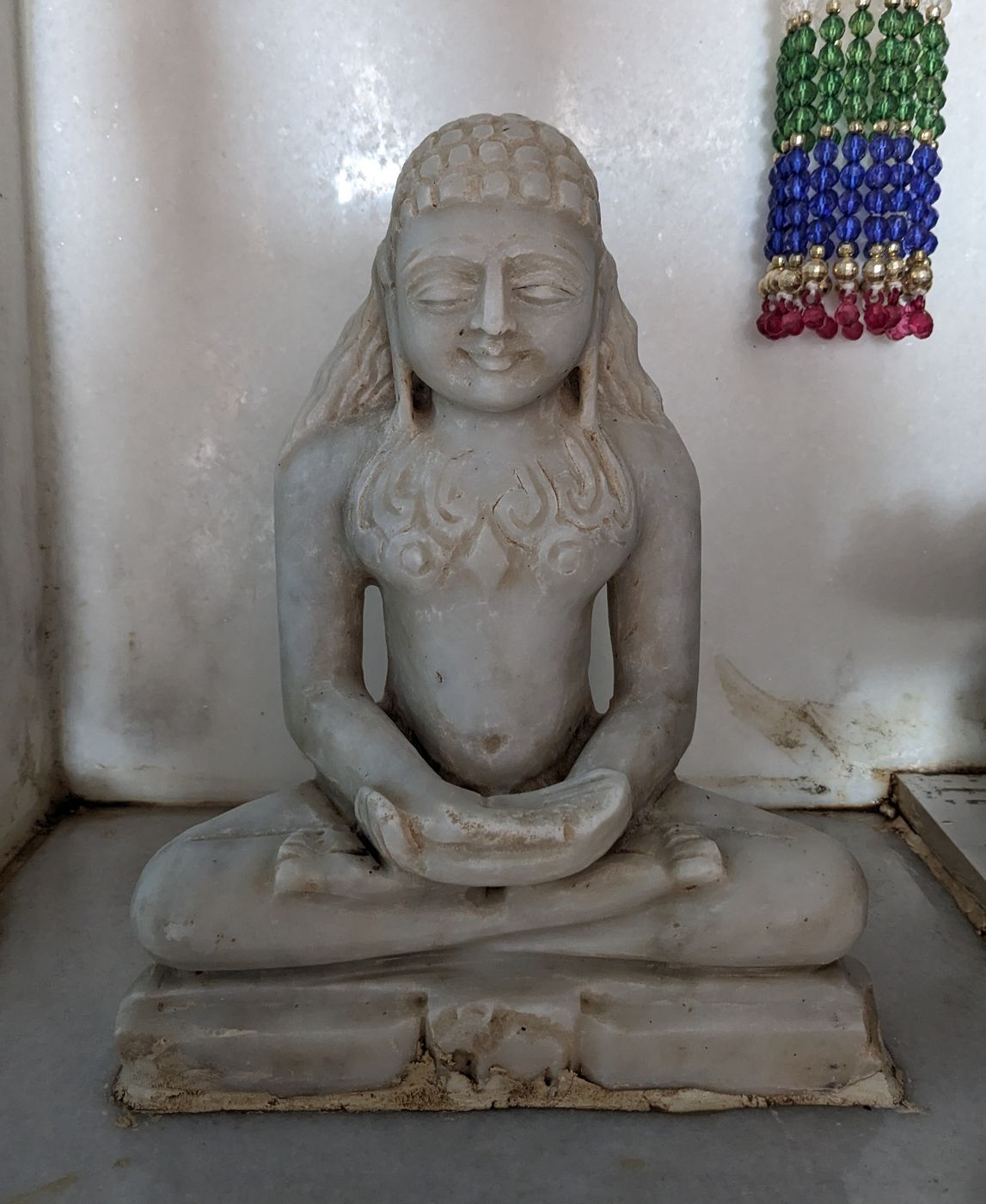 Marble murti of Rishabhanatha with locks of hair falling on both shoulders